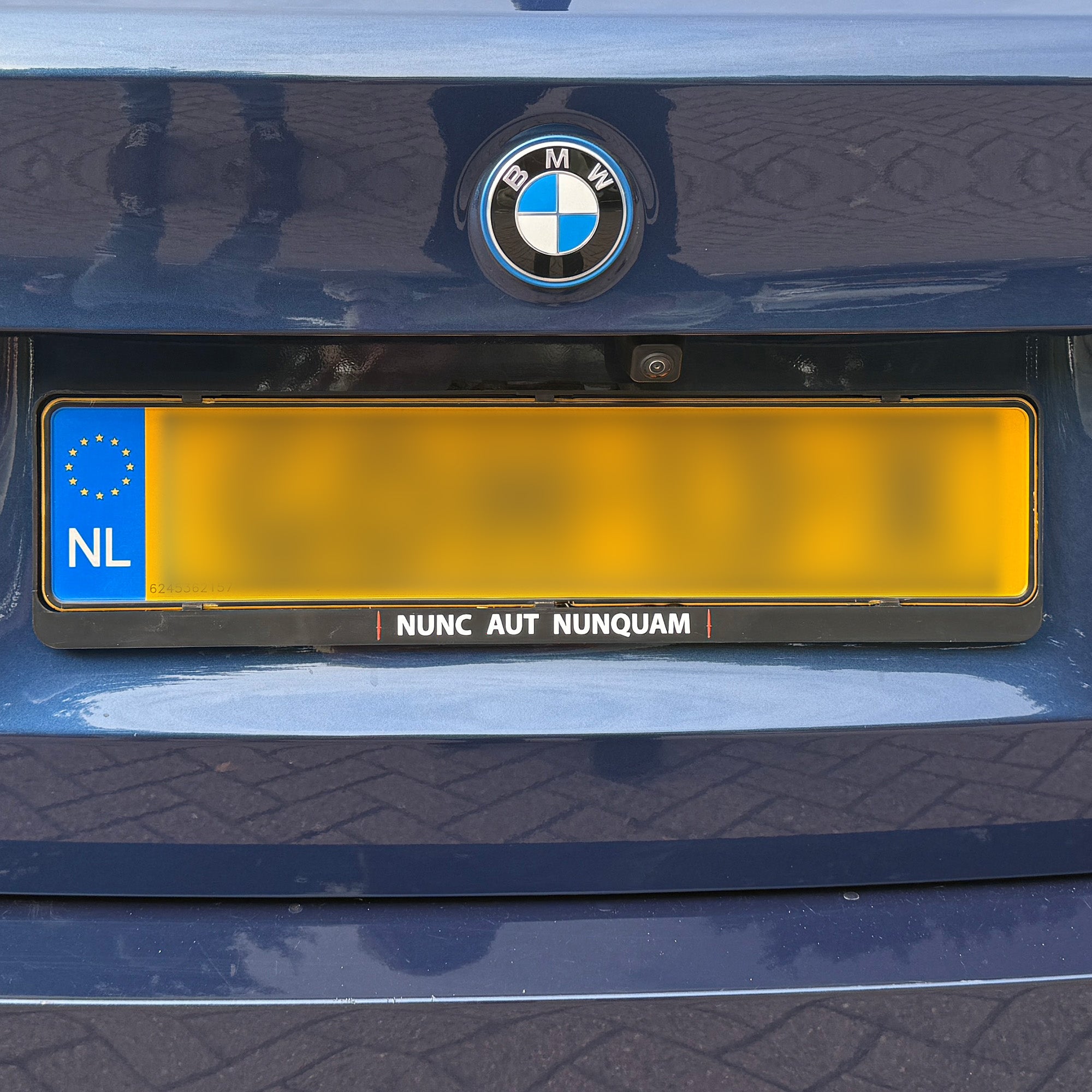 Kentekenplaathouder met tekst Nunc Aut Nunquam en rode dolkjes